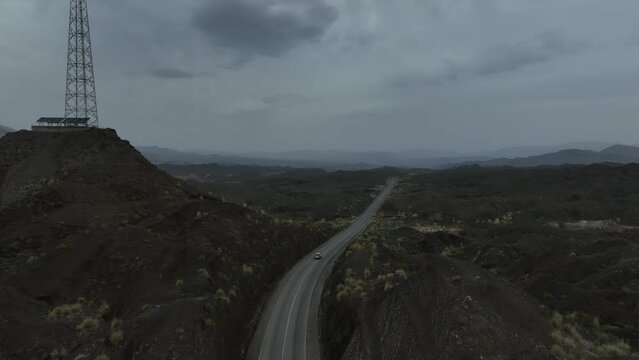 Aerial drone footage following a car driving through a mountain landscape in Balochistan