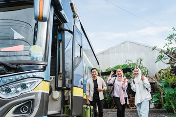 happy asian muslim passengers lined up in line to get on the bus