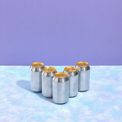 Refreshing drink. Five aluminum cans of various carbonated drinks are on the table. Copy space for text.