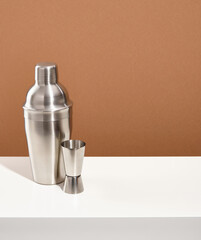 Metal shaker and jigger for making alcoholic cocktails. Copy space for text. Night funny relax.