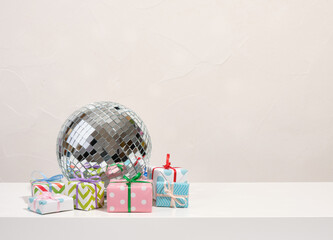 A shining disco ball and lots of different birthday presents. Party at the club. Copy space for text.
