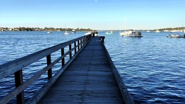 Looking down Long Jetty to boats on Swan River at Peppermint Grove, Perth, Western Australia
