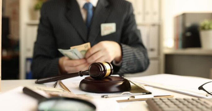 Man in business suit counts cash and throws it onto judge wooden gavel. Bribery and fraud of Judges and advocates concept