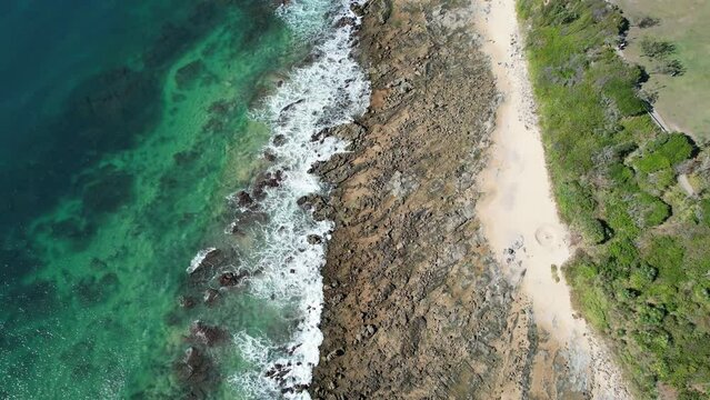 Rocky Shoreline Of Mooloolaba Beach With Resort Hotels In Queensland, Australia. aerial tilt-up
