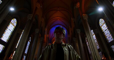 Stylish young attractive man in church rolls up his sleeves. An old Catholic church. The pastor is preparing to give a sermon. High quality 4k footage