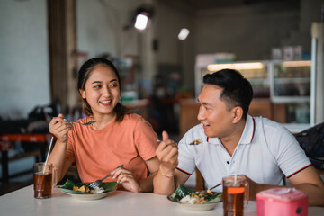 Asian couple enjoying a meal together at a traditional food stall