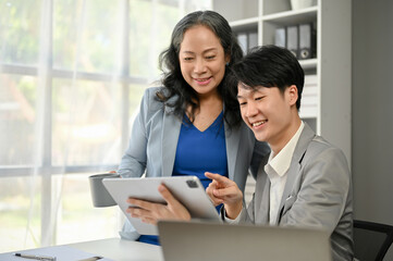 A smart Asian businessman discussing work and working with a senior businesswoman