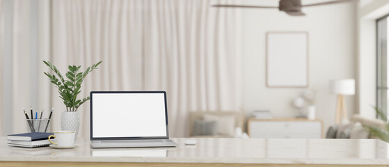 Workspace with a laptop mockup on a white tabletop in a beautiful minimalist living room.