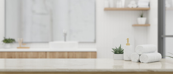 Fototapeta na wymiar A shampoo bottle, towels, and copy space on a white tabletop in a beautiful white bathroom.