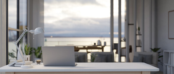Back view of a modern workspace with a laptop and office supplies on a table