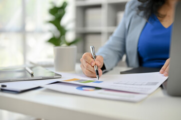 Close-up image of a professional businesswoman reviewing financial reports