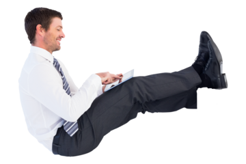 Digital png photo of happy caucasian businessman sitting and using tablet on transparent background