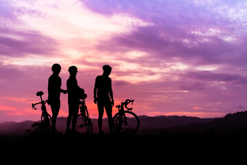 A silhouette of a cyclist on a mountain bike riding in a dramatic sunset