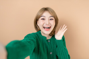 Self-portrait of attractive girl spending weekend isolated on beige background