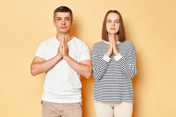 Calm relaxed young couple friends man woman in casual clothing isolated over beige background...
