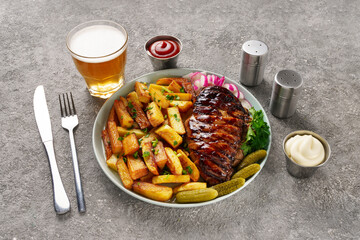 American lunch with juicy steak and beer, served with french fries, radishes and herbs