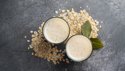 A glass of lean oatmeal milk on a stone background. vegetarian and organic drink food. top view.