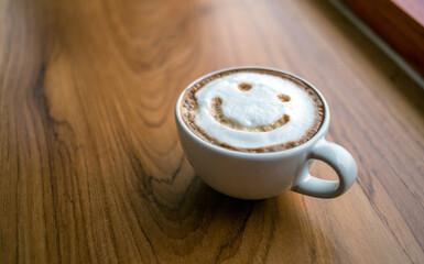 Cup of cappuccino coffee delicious hot coffee with foam milk and smile on color background, top view. Happy morning, good mood, inspiration