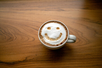 Cup of cappuccino coffee delicious hot coffee with foam milk and smile on color background, top view. Happy morning, good mood, inspiration