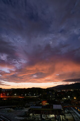 Dramatic landscape with view on evening city. Beautiful cloudy sky.