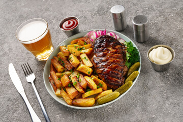 American lunch with juicy steak and beer, served with french fries, radishes and herbs