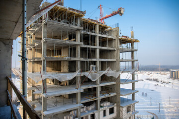 The construction of a high-rise and large building for people to live. New multi-storey building under construction in the city
