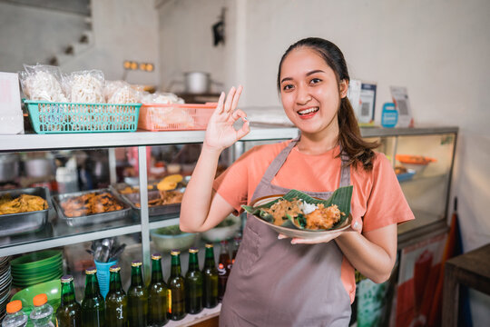 Beautiful Asian Girl With Okay Hand Gestures Carrying A Plate Of Pecel Rice Food At A Food Stall