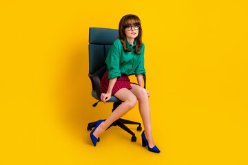 Full length photo of scared afraid woman dressed green shirt sitting armchair biting lip isolated yellow color background