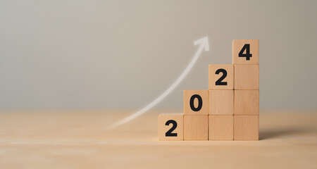Business growth concept in 2024. Business goals and achievement. Sustainable development. Wooden cubes inscripted 2024 and growth icon on smart background. Positive indicators banner.