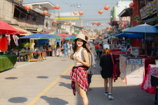 Asian traveler walking on festival at outdoor market. Festive mood, Travel and holidays, Backpacker concept.