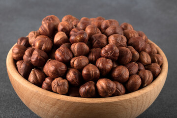 View of a bowl full of hazelnuts on a black background
