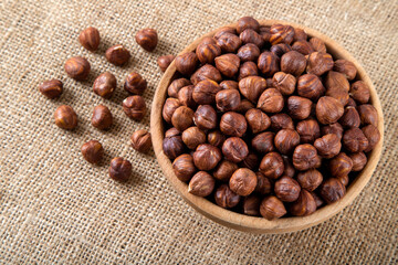 View of a bowl full of hazelnuts on burlap sack,top view
