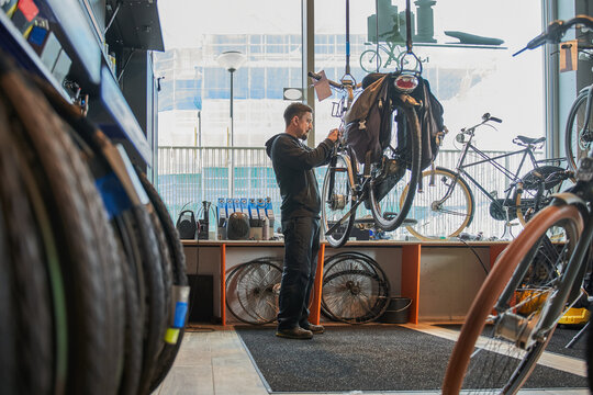 Full length view of the man working in a bicycle repair shop