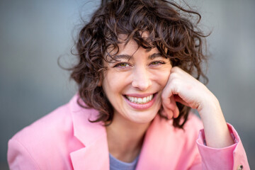 Happy young woman with hand on chin smiling at camera
