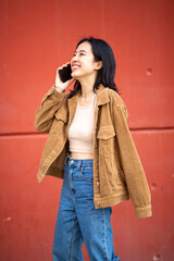 happy young woman walking and talking with mobile phone