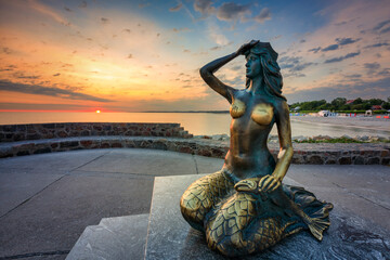 Mermaid statue by the Baltic Seain Ustka at sunrise. Poland - obrazy, fototapety, plakaty