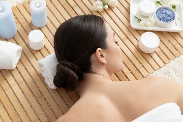 Obraz na płótnie Canvas Brunette woman on massage, jars with body cream, wooden background