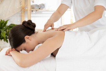 Obraz na płótnie Canvas Brunette woman on massage, white towels and masseur's hands