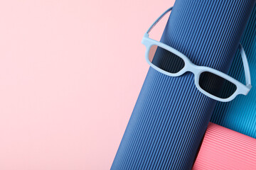 Blue sunglasses on blue and pink background, space for text