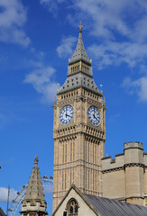 Big Ben Clock Tower in London, UK in a day with white clouds and blue sky.