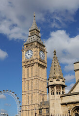 Big Ben Clock Tower in London,houses of parliament and London eye, UK, in a day with white clouds and blue sky.