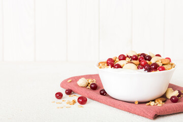 Healthy breakfast food with granola, yogurt, fruits and nuts. Dessert parfait with dried fruits for breakfast