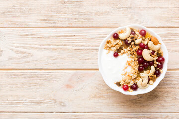 Healthy breakfast food with granola, yogurt, fruits and nuts. Dessert parfait with dried fruits for breakfast