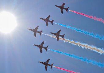 british raf red arrows falcons aerobatic team fighter jet with blue skies in formation with white red and blue smoke trail air show display teams manoeuvre  - obrazy, fototapety, plakaty