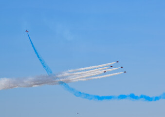 british raf red arrows falcons aerobatic team fighter jet with blue skies in formation with white red and blue smoke trail air show display teams manoeuvre 