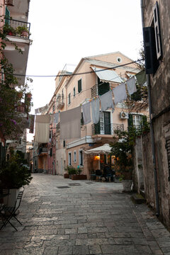 Rustic street with white clothes drying on line in Corfu old town in greece