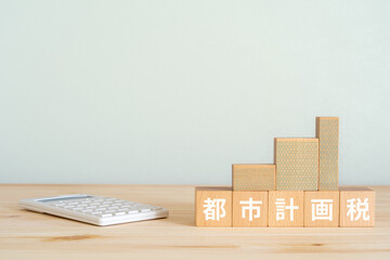 都市計画税と書かれたブロック、電卓、ミニチュアの建物