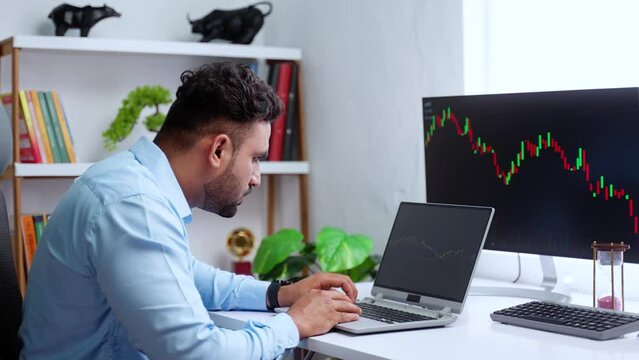 Indian trader or stock Market broker analysing candle stick graphs on laptop at office - concept of Investment opportunities, Trading strategies and Price movements