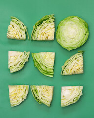 Cabbage cut into pieces top view on a green background
