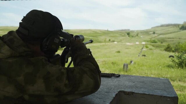 Rear view of a man shooting a rifle at a target. Shooting competitions